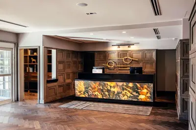a kitchen with wooden cabinets and a counter top at Somerset Hills Hotel, Tapestry Collection by Hilton in Basking Ridge