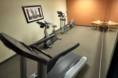 a gym with several exercise bikes in a room at Lancaster Inn & Suites in Manheim