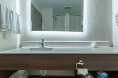 a bathroom with a sink and a mirror at Lancaster Inn & Suites in Manheim