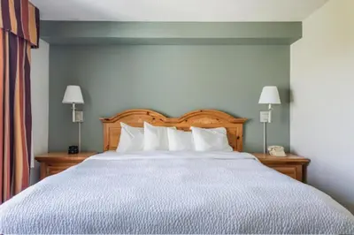 a bedroom with a large bed with white pillows at Lancaster Inn & Suites in Manheim