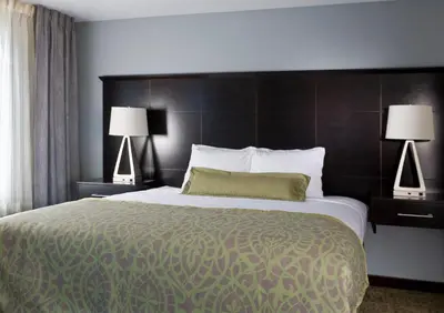 a large bed in a hotel room with two lamps at Staybridge Suites Montgomeryville by IHG in North Wales