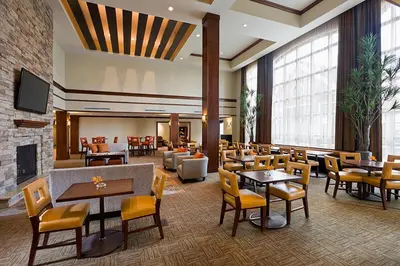 a restaurant with tables and chairs and a fireplace at Staybridge Suites Montgomeryville by IHG in North Wales