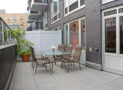 a patio with a table and chairs on a balcony at Sanctuary NYC Retreats in New York
