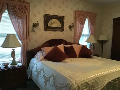 a bedroom with a bed with white sheets and pillows at Brookview Manor Inn in Canadensis