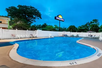 a pool at a resort with chairs and a sign at Days Inn by Wyndham Tannersville in Tannersville