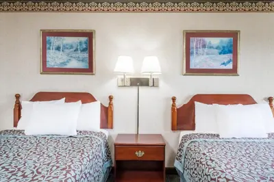 two beds in a hotel room with two lamps at Days Inn by Wyndham Tannersville in Tannersville