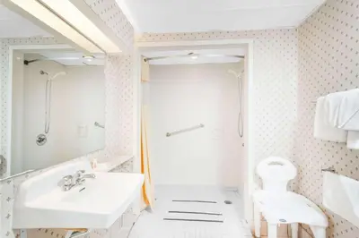 a white bathroom with a sink and a toilet at Days Inn by Wyndham Tannersville in Tannersville