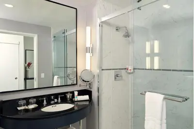 a bathroom with a sink and a shower with a mirror at Loews Philadelphia Hotel in Philadelphia