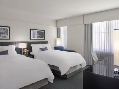 a hotel room with two beds and a desk at Loews Philadelphia Hotel in Philadelphia
