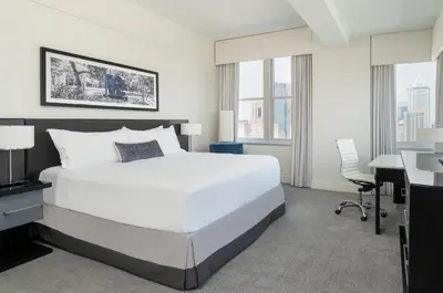 a bedroom with a large white bed and a desk at Loews Philadelphia Hotel in Philadelphia