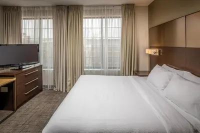 a hotel room with a large bed and a flat screen tv at Residence Inn by Marriott Williamsport in Williamsport