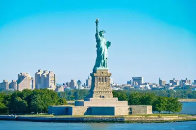the statue of liberty in front of the city at NYC Empire Apartments in New York