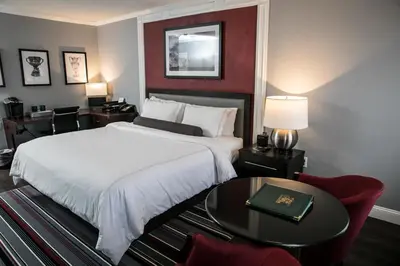 a hotel room with a large bed and a table at The Olde Mill Inn Basking Ridge in Basking Ridge