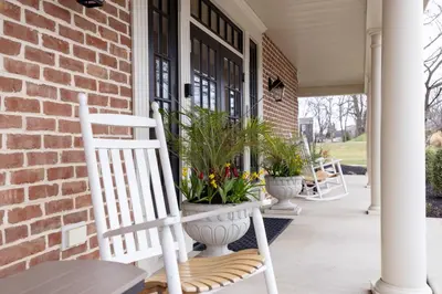 a white rocking chair on a porch with plants at Selinsgrove Inn in Selinsgrove