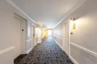 a hallway with white walls and a tile floor and white doors at Selinsgrove Inn in Selinsgrove