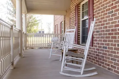 two white rocking chairs on the porch of a house at Selinsgrove Inn in Selinsgrove