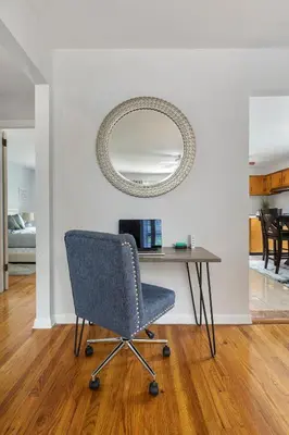 a chair sitting in front of a table with a mirror at Close to NYC | King Bed | Free Parking in Bloomfield