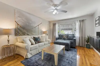 a living room with a couch and a table at Close to NYC | King Bed | Free Parking in Bloomfield