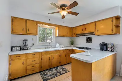 a kitchen with wooden cabinets and a ceiling fan at Close to NYC | King Bed | Free Parking in Bloomfield