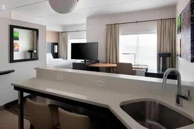 a hotel room with a sink and a bedroom at Residence Inn by Marriott Lancaster in Lancaster