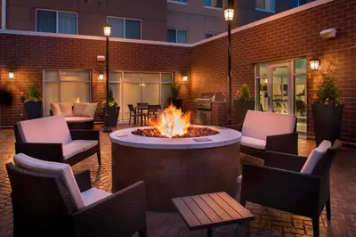 a patio with a fire pit and chairs and a building at Residence Inn by Marriott Lancaster in Lancaster
