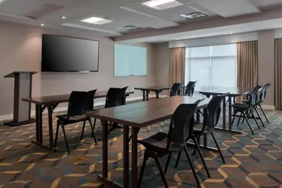 a conference room with tables and chairs and a projection screen at Residence Inn by Marriott Lancaster in Lancaster