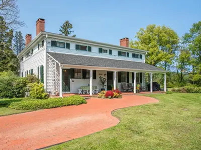 a white house with a red brick driveway at The Neighbour House B&B in Long Valley