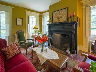 a living room with a fireplace and a red couch at The Neighbour House B&B in Long Valley