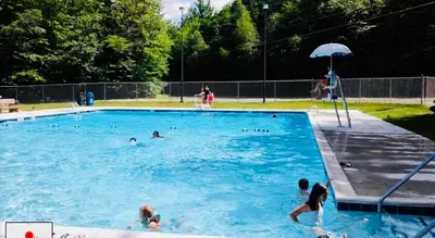 a group of people swimming in a swimming pool at Mt. Maplewood Chalet in Pocono Lake