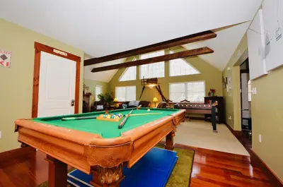 a living room with a pool table in it at Mt. Maplewood Split Chalet in Pocono Lake