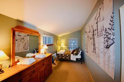 a bathroom with a dresser and a mirror and a bedroom at Mt. Maplewood Split Chalet in Pocono Lake