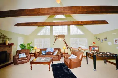 a living room with leather furniture and a table at Mt. Maplewood Split Chalet in Pocono Lake