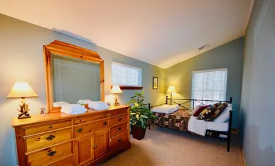 a bedroom with a bed and a dresser with a mirror at Mt. Maplewood Split Chalet in Pocono Lake
