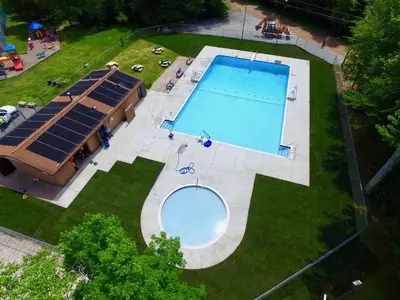 an overhead view of a swimming pool with solar panels at Mt. Maplewood Split Chalet in Pocono Lake