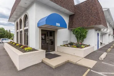 a store front with a blue awning and flowers at Motel 6-Warminster, PA in Warminster