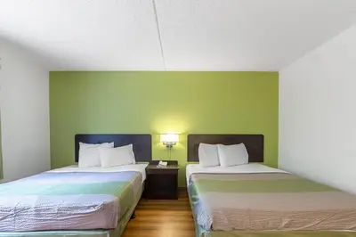 two beds in a room with green walls at Motel 6-Warminster, PA in Warminster