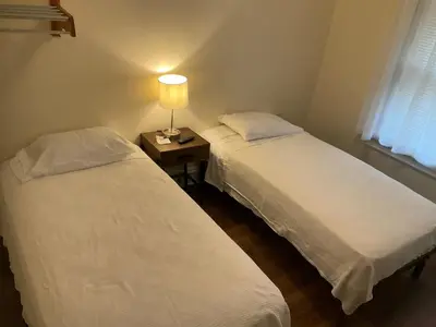 two beds in a room with a lamp on a table at Cappuccio Hotel in Keansburg