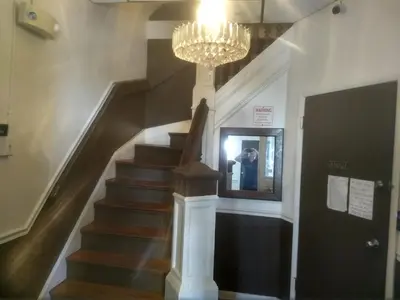 a man taking a picture of a staircase with a chandelier at Cappuccio Hotel in Keansburg