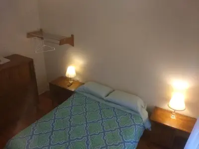 a bedroom with a bed and two lights on two tables at Cappuccio Hotel in Keansburg