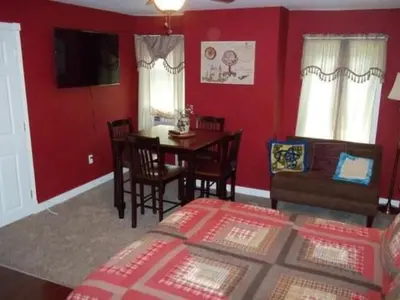 a bedroom with a bed and a table and chairs at Tin Brook Bed & Breakfast in Walden