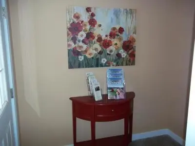 a small wooden table with a painting on the wall at Tin Brook Bed & Breakfast in Walden