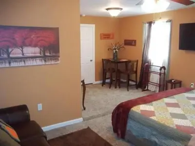 a bedroom with a bed and a table and a window at Tin Brook Bed & Breakfast in Walden