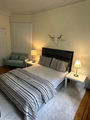 a bedroom with a bed and two tables with lamps at TIME SQUARE 42nd Street Private Room in New York