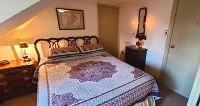 a bedroom with a bed with a purple comforter at General Warren in Malvern
