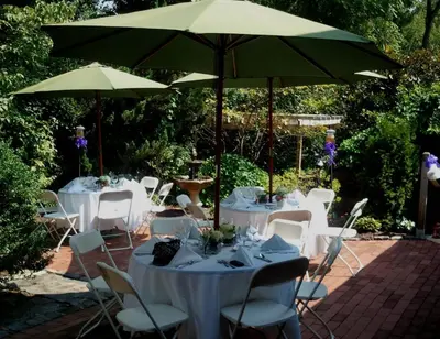 a group of tables and chairs under an umbrella at General Warren in Malvern