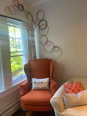 a room with a chair with a pillow and a window at Elegantly English Catskills in Liberty