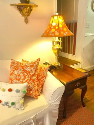 a lamp on a table next to a bed with pillows at Elegantly English Catskills in Liberty