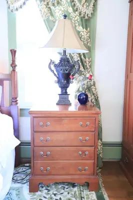 a lamp on top of a dresser in a bedroom at Elegantly English Catskills in Liberty