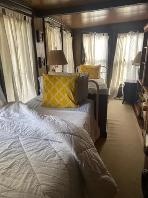 a bedroom with two beds with yellow pillows at Elegantly English Catskills in Liberty