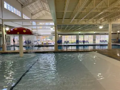 an empty swimming pool with an umbrella in a building at Pocono Villas Resort in East Stroudsburg